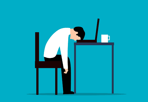 person at their desk exhausted by their work